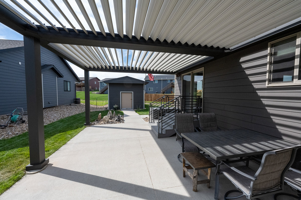 House attached pergol installed over patio with outdoor seating.