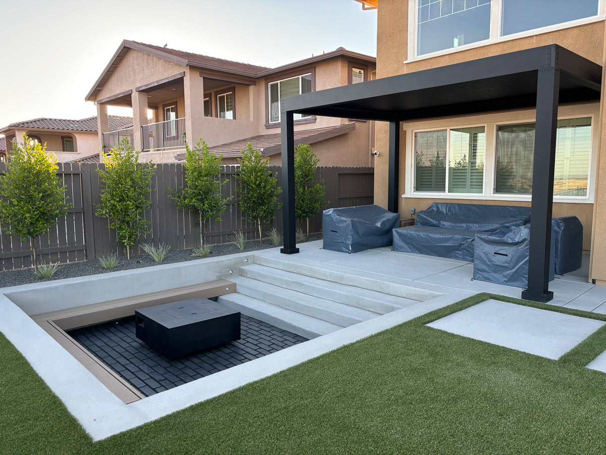 sunken sitting area with fire place outdoor living space with black louvered roof pergola structure