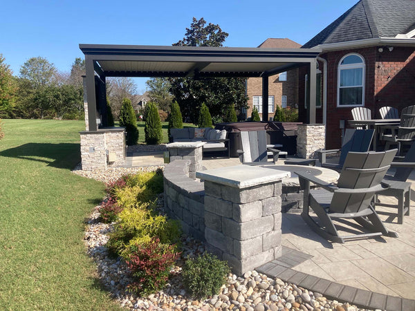Black louvered pergola with stone fire pit and dining chairs, brick house