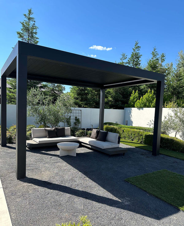 Black aluminum pergola with louvered roof over seating beside swimming pool