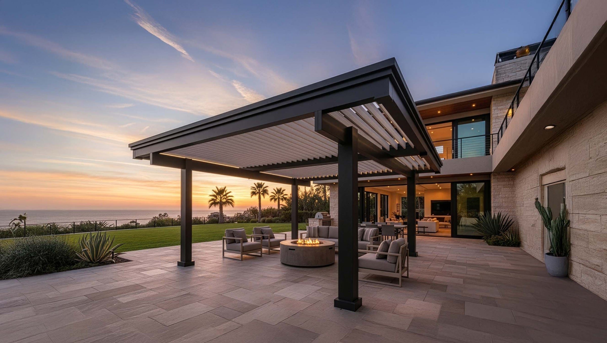 Outdoor patio area with a fire pit and pergola at sunset.