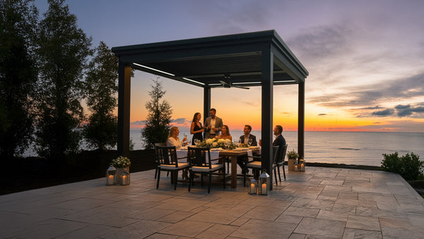 Group of people dining under a pergola by the sea at sunset.