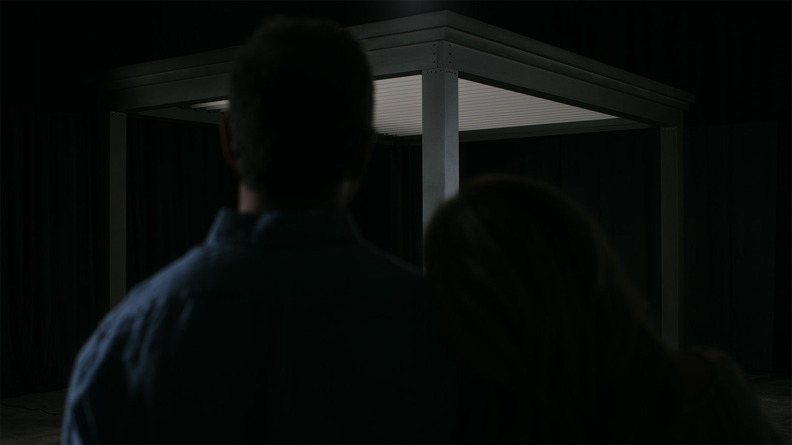 Modern charcoal pergola with white louvered roof at night