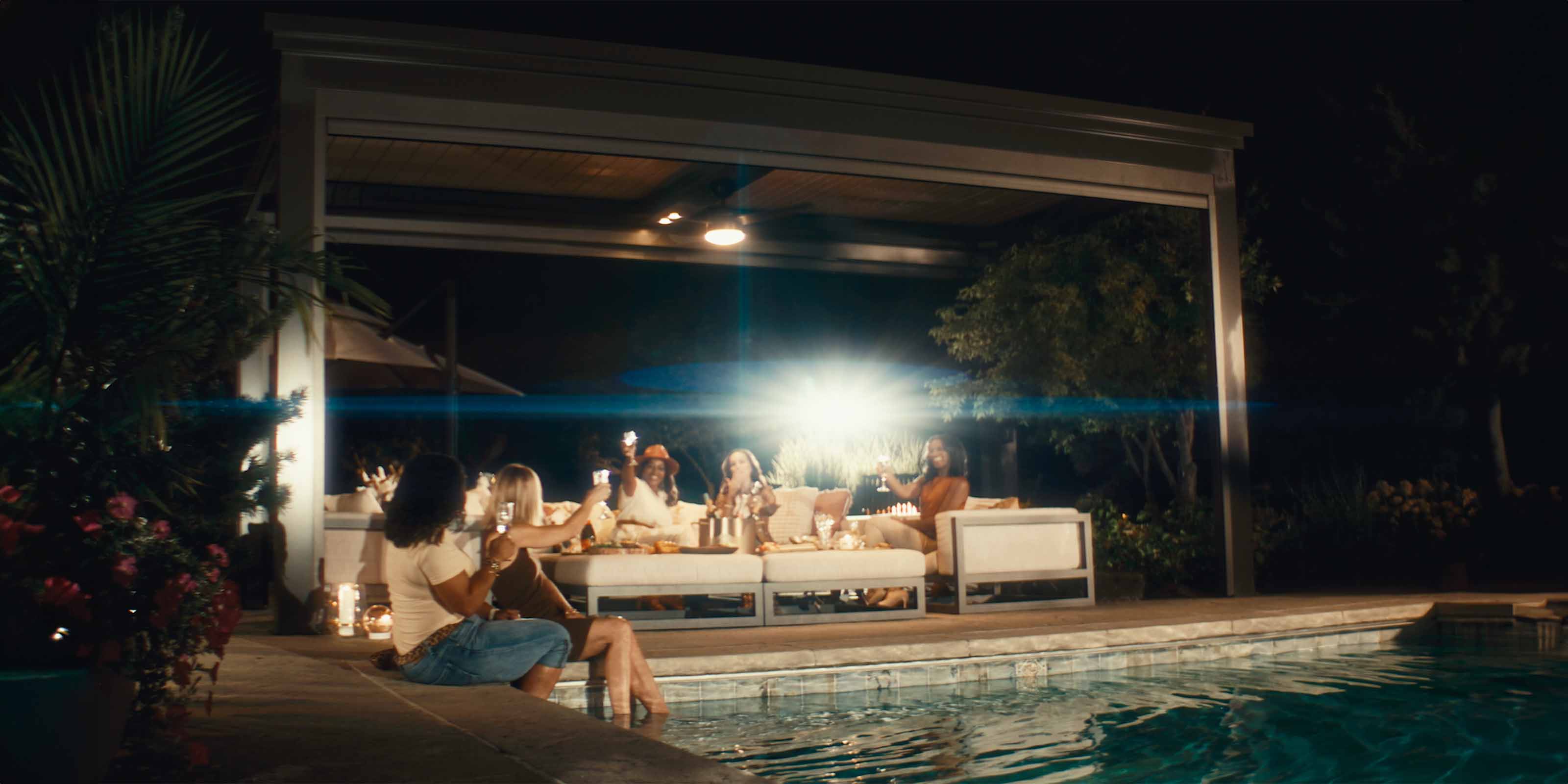 women by pool with luxury pergola in background