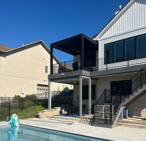 Black pergola with modern design over patio with railing, pool visible