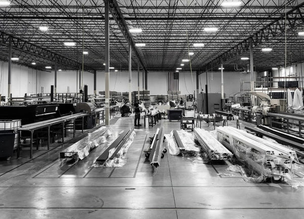Factory interior with large industrial equipment and materials on a polished floor.