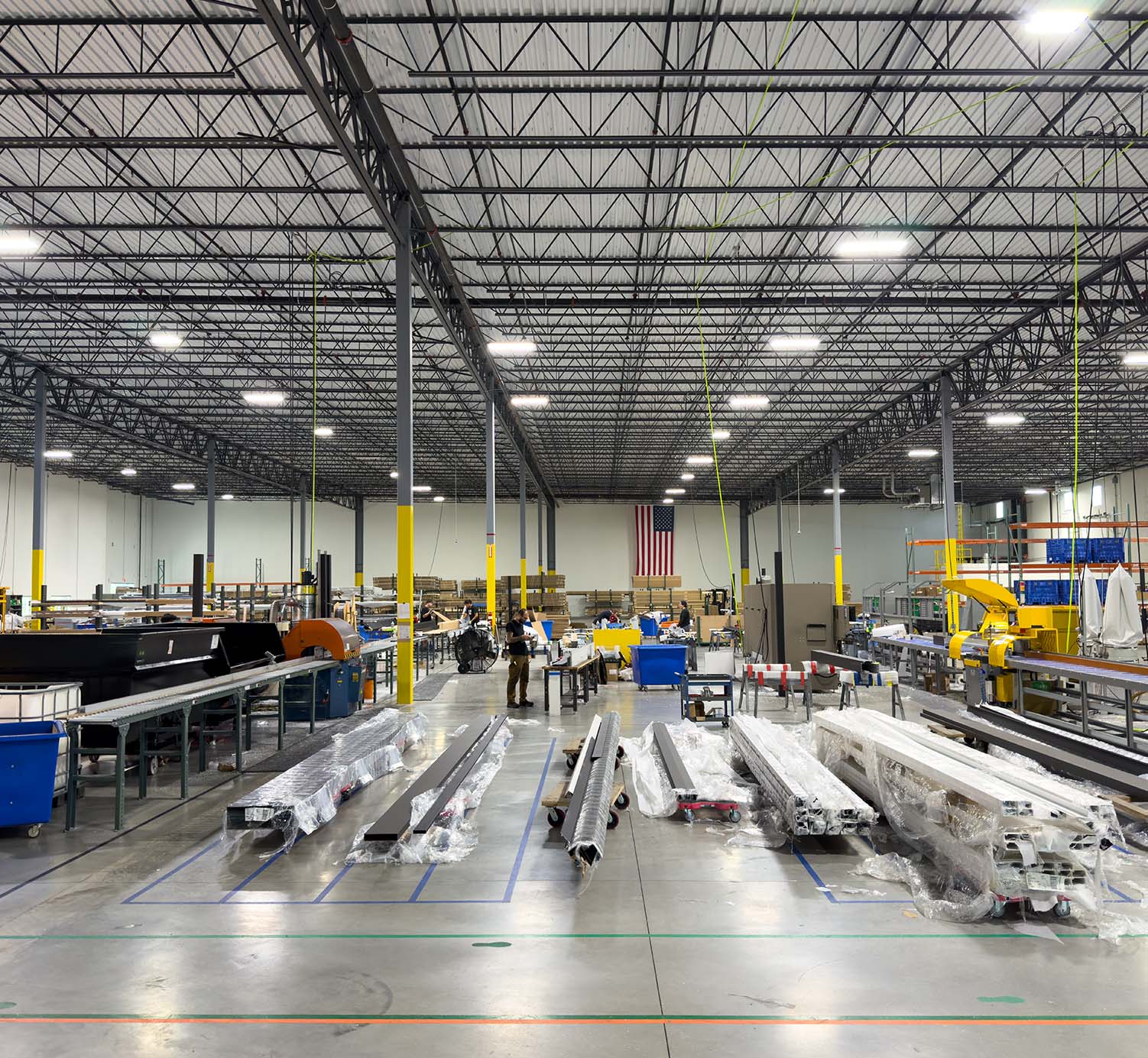 Large industrial warehouse with various equipment and materials on the floor.